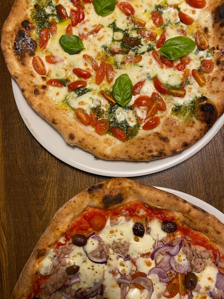 Zwei frisch gebackene Pizzen auf dem Tisch
